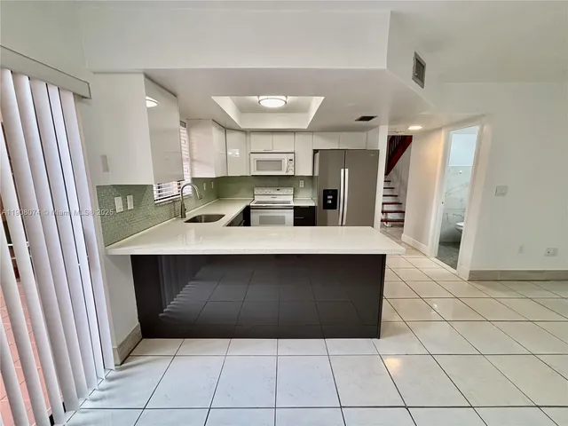 a kitchen with kitchen island cabinets and refrigerator