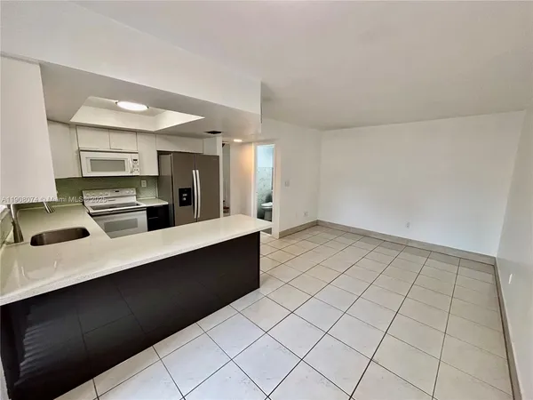 a large white kitchen with a sink and cabinets