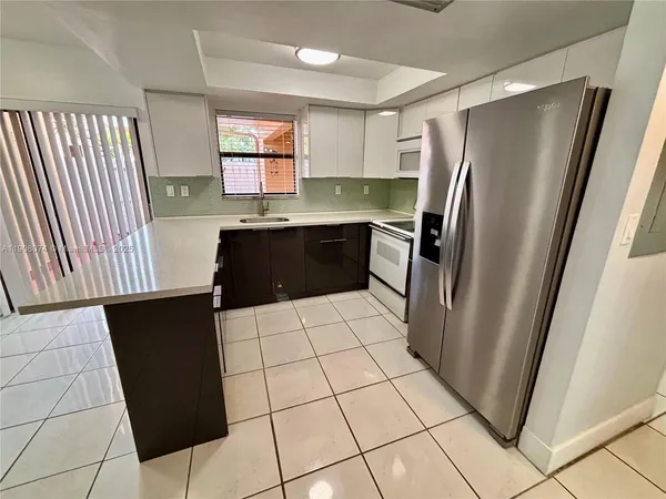 a kitchen with stainless steel appliances a refrigerator a sink a counter top space and cabinets