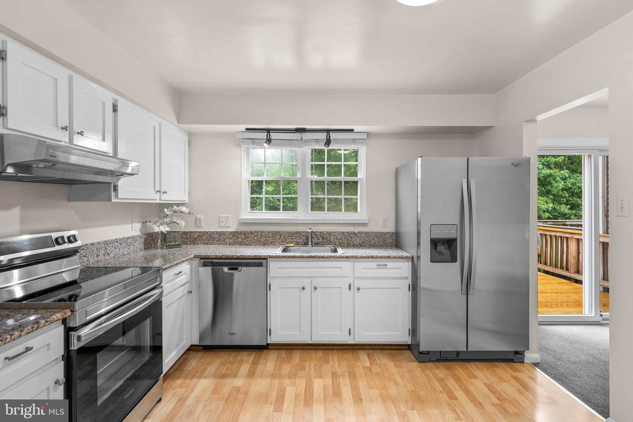 17513 Longview Lane Olney, MD 20832 - Photo 2 of 51 a kitchen with stainless steel appliances granite countertop a stove a sink dishwasher a refrigerator and white cabinets with wooden floor