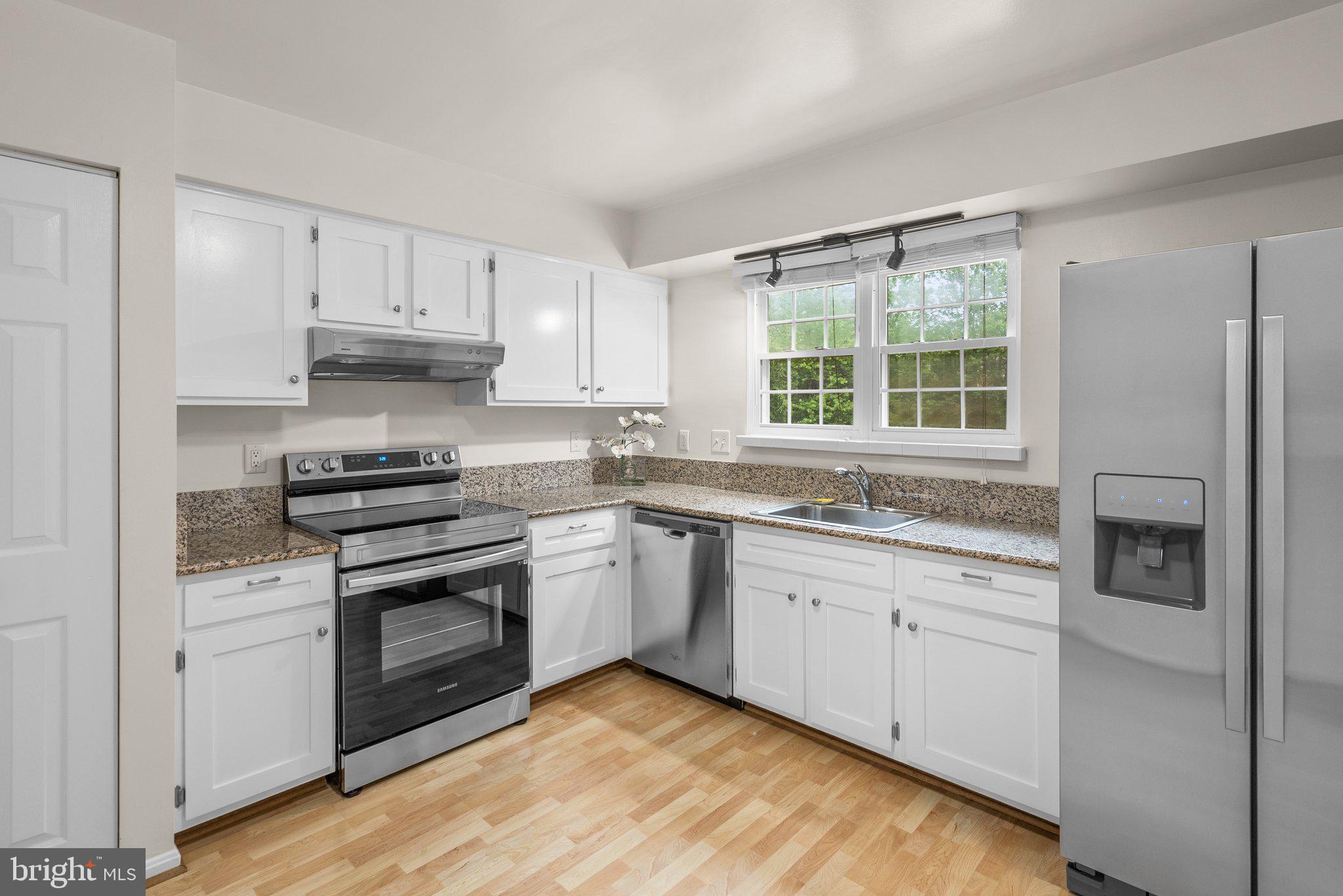 17513 Longview Lane Olney, MD 20832 - Photo 22 of 51 a kitchen with stainless steel appliances granite countertop a sink a stove a refrigerator and white cabinets