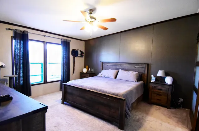 a bedroom with a bed and a large window