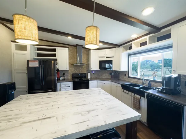 a kitchen with stainless steel appliances kitchen island granite countertop a stove a sink and a refrigerator