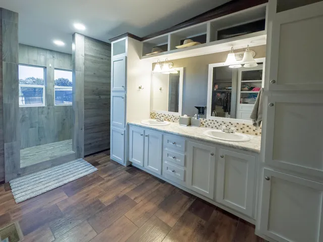 a spacious bathroom with a granite countertop sink mirror and shower