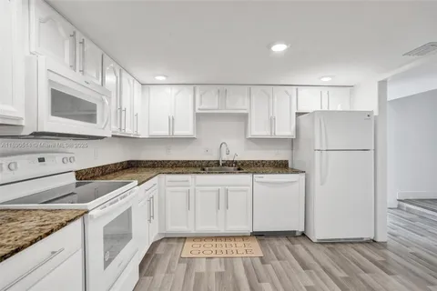 a kitchen with stainless steel appliances granite countertop a stove a refrigerator and a microwave