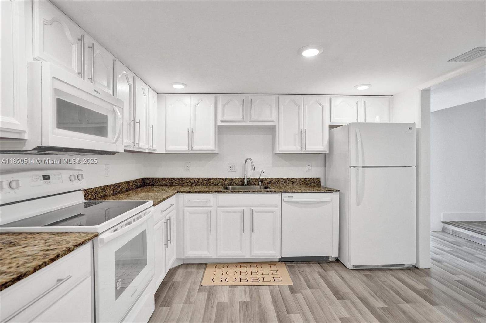 a kitchen with stainless steel appliances granite countertop a stove a refrigerator and a microwave