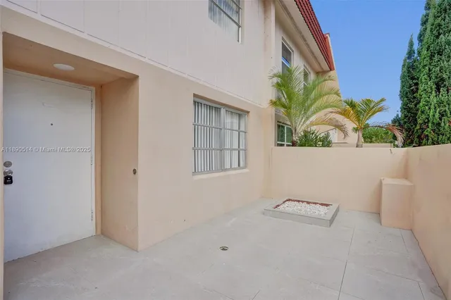a view of an empty room with a window and potted plants