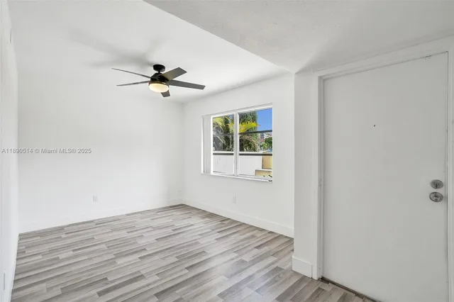 a view of a room with wooden floor and a ceiling fan