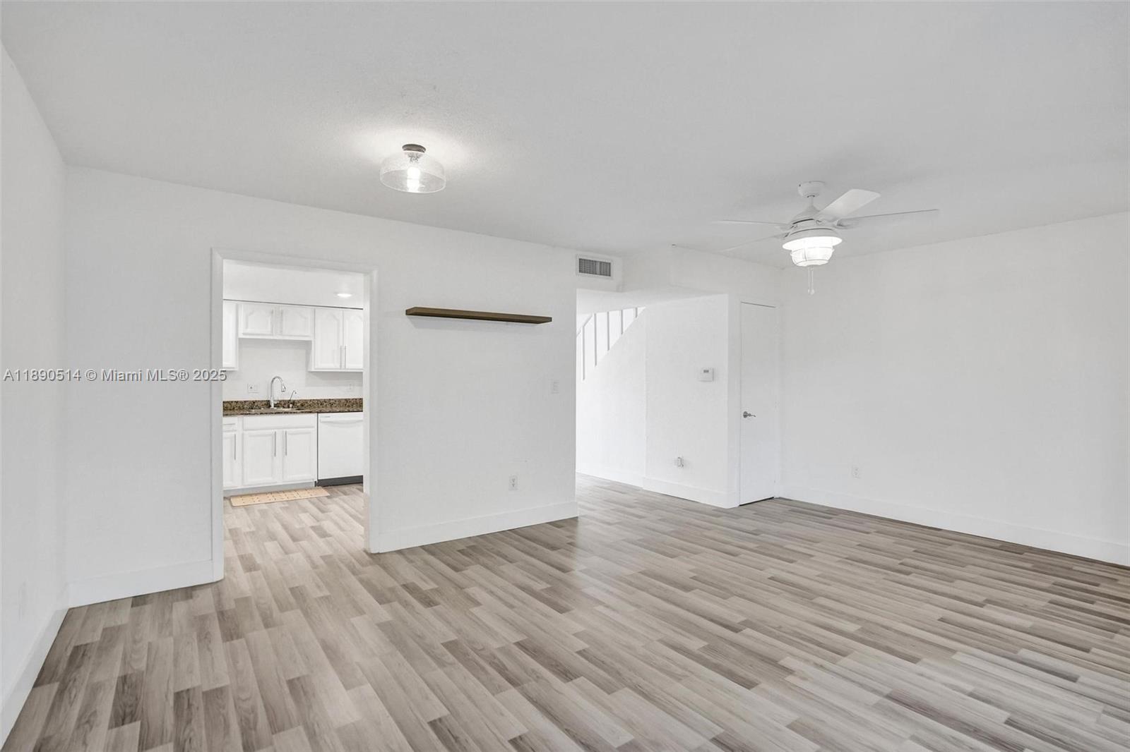 4026 Inverrary Drive, Unit 8A Lauderhill, FL 33319 - Photo 19 of 50 a view of empty room with wooden floor and kitchen