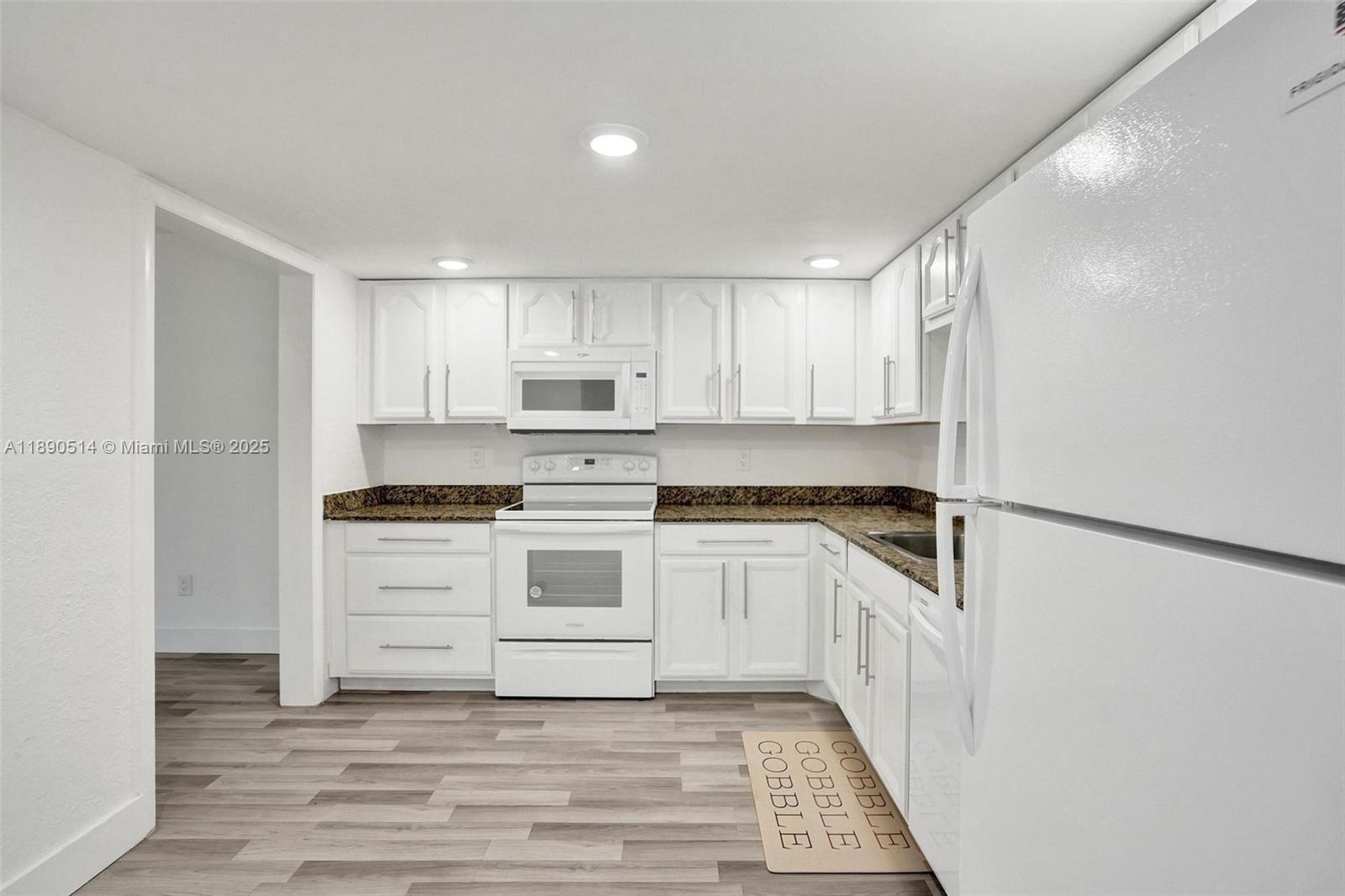 4026 Inverrary Drive, Unit 8A Lauderhill, FL 33319 - Photo 3 of 50 a kitchen with white cabinets and white appliances