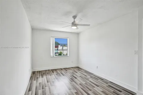 an empty room with a window and a ceiling fan