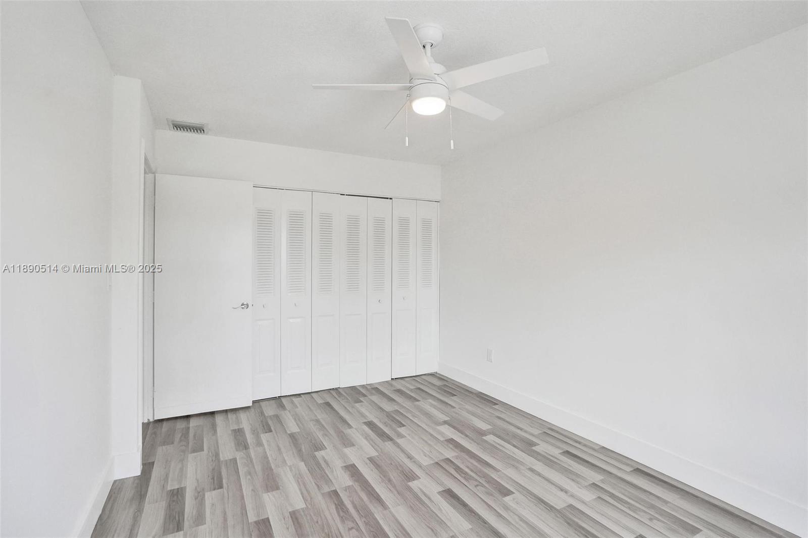 4026 Inverrary Drive, Unit 8A Lauderhill, FL 33319 - Photo 37 of 50 a view of a room with wooden floor and a ceiling fan