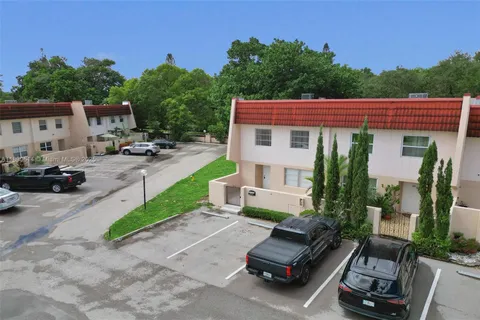 a view of a patio with couches table and chairs under an umbrella with a fire pit