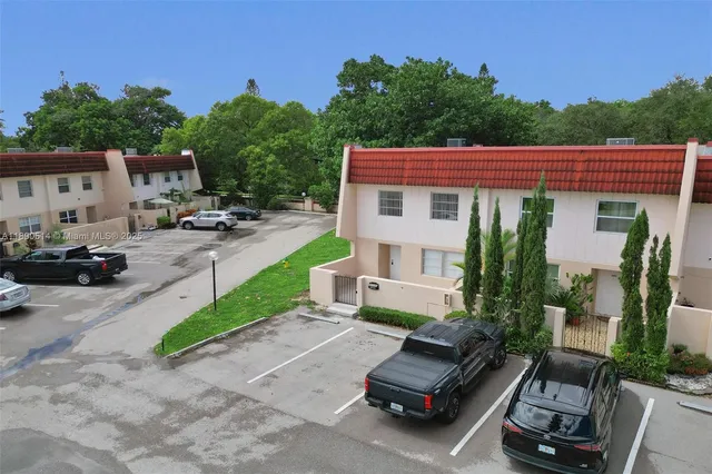 a view of a patio with couches table and chairs under an umbrella with a fire pit