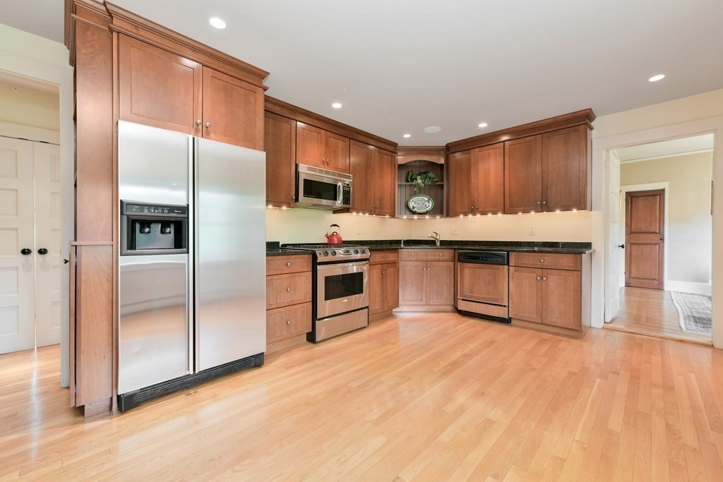 241 Central Street Hingham, MA 02043 - Photo 6 of 24 a large kitchen with stainless steel appliances granite countertop a stove a sink dishwasher a refrigerator and a oven with wooden floor