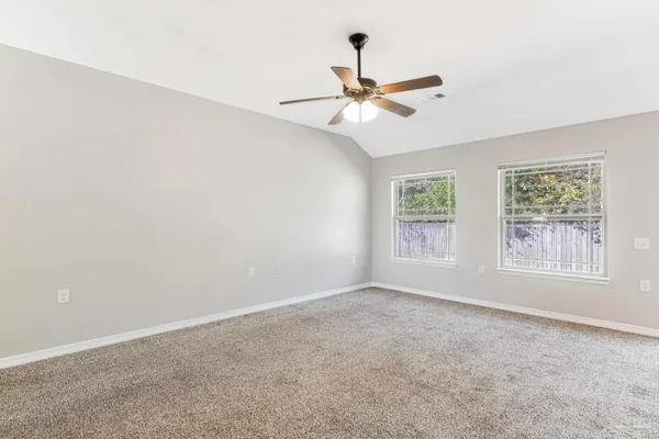an empty room with windows and fan