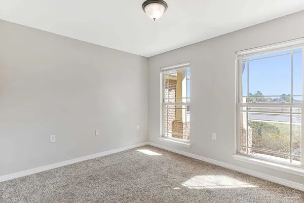 an empty room with windows and closet