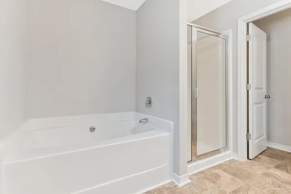 a white bath tub sitting next to a shower