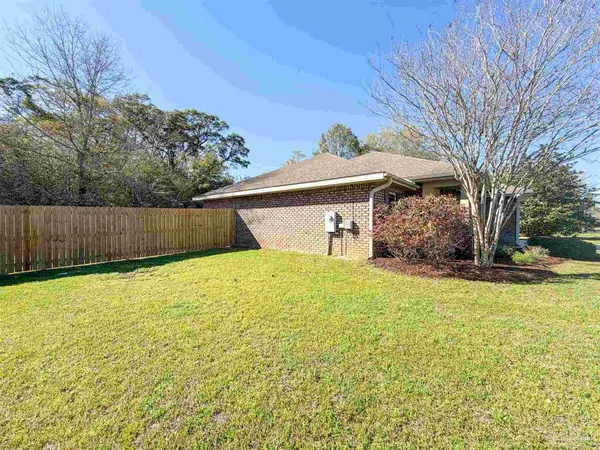 a front view of house with yard and trees in the background