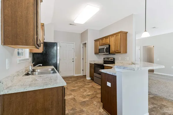 a kitchen with granite countertop a sink stove and refrigerator