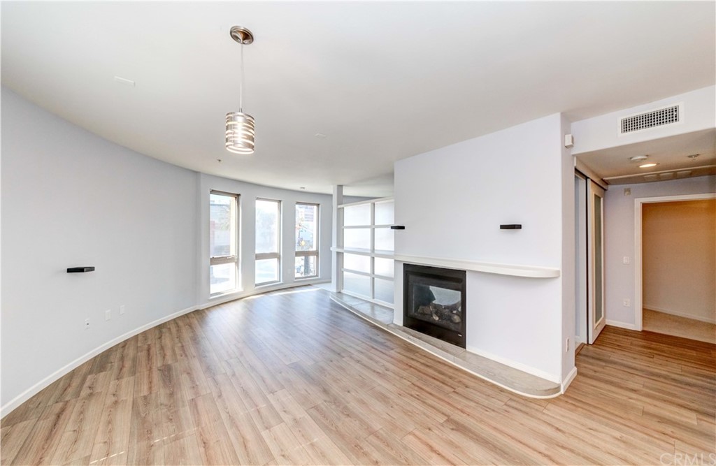 100 South Alameda Street, Unit 210 Los Angeles, CA 90012 - Photo 8 of 52 a view of an empty room with wooden floor and a window