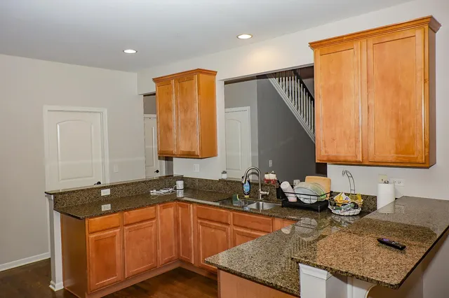 a kitchen with granite countertop sink stove and cabinets