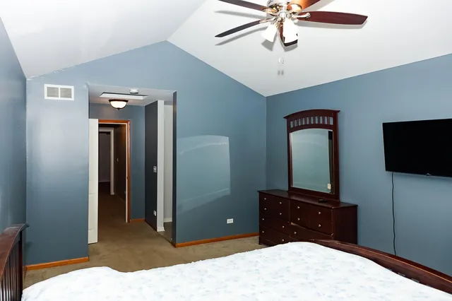 a bedroom with a bed and a flat tv screen on dresser