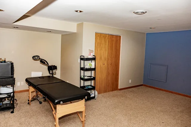 a living room with a table chairs and a refrigerator