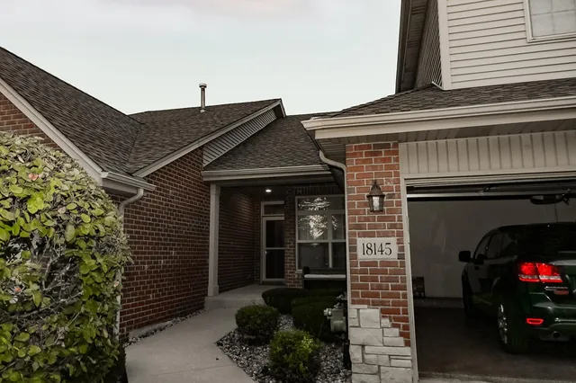 a view of a house with a small yard and potted plants