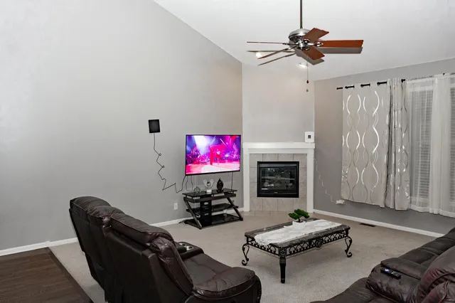 a living room with furniture a fireplace and a flat screen tv