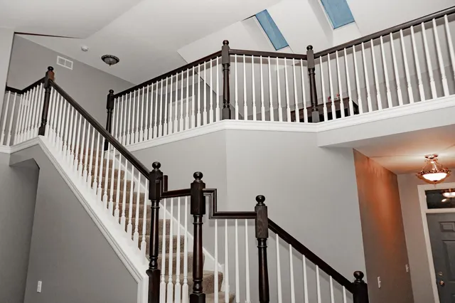 a view of staircase with railing and white walls