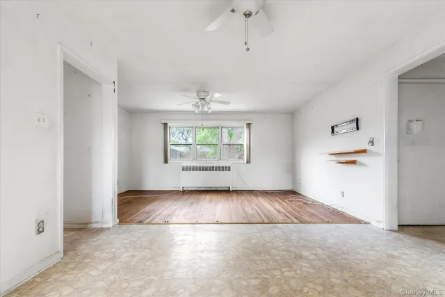 an empty room with windows and chandelier