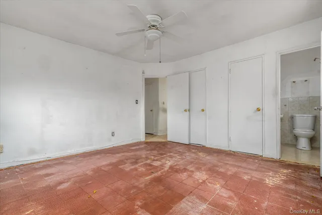 a view of an empty room and a chandelier fan