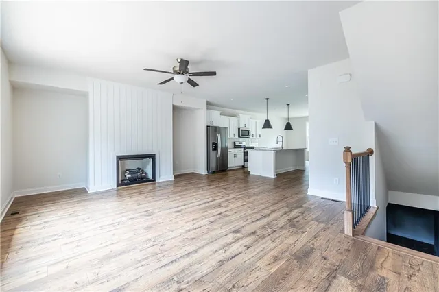 a view of a kitchen with wooden floor and a fireplace