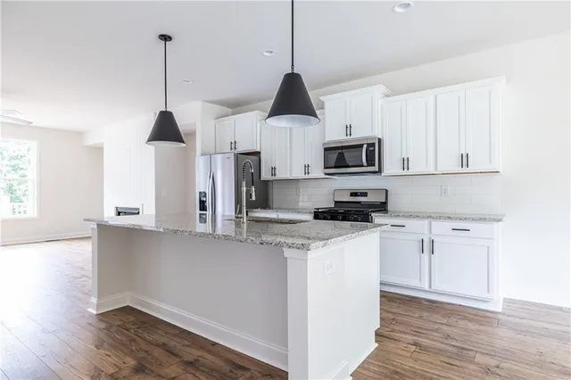 a kitchen with stainless steel appliances granite countertop a stove a sink and a granite counter top