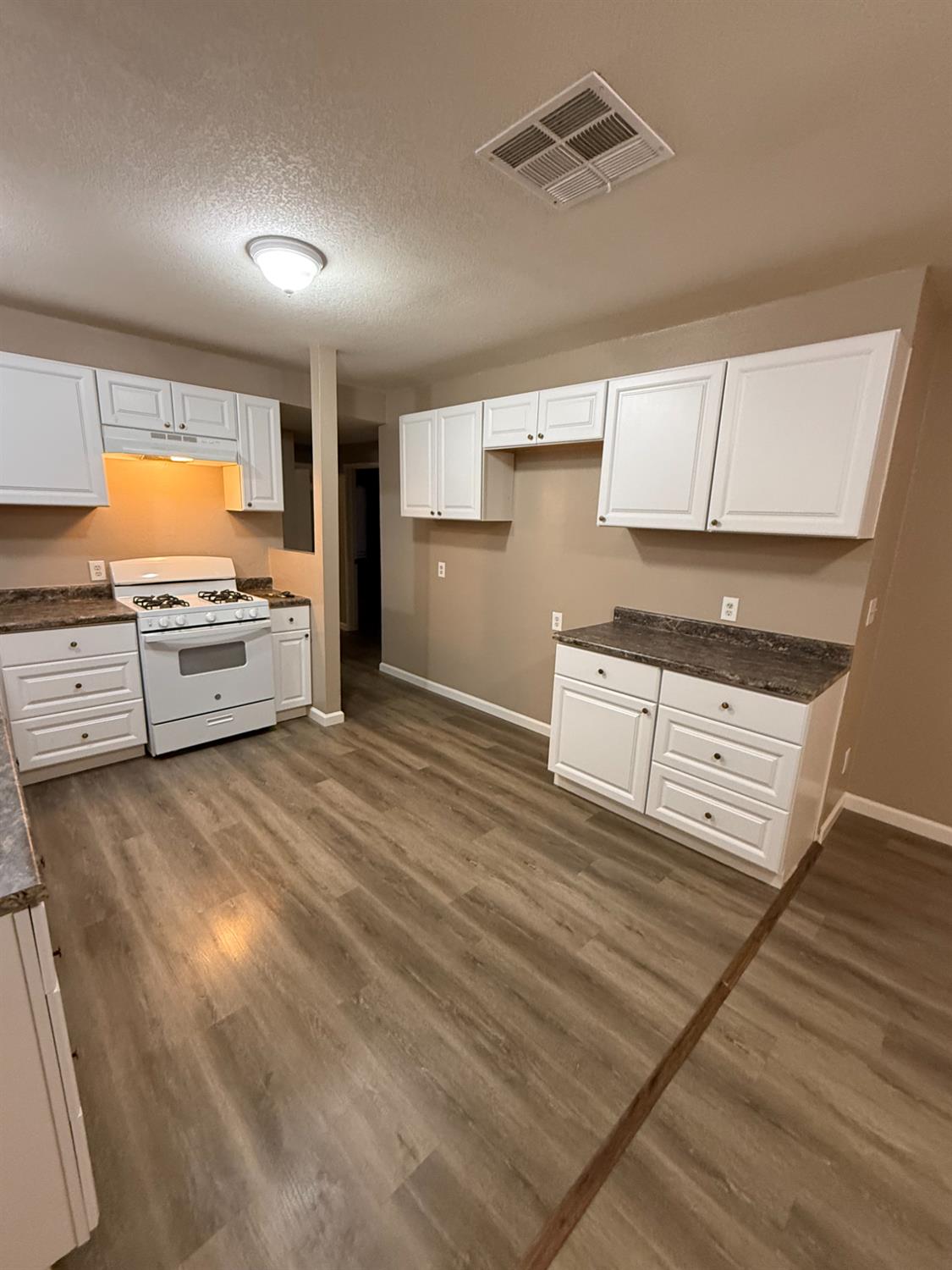 460 South Dearing Avenue Fresno, CA 93702 - Photo 15 of 23 a large kitchen with cabinets wooden floor and stainless steel appliances