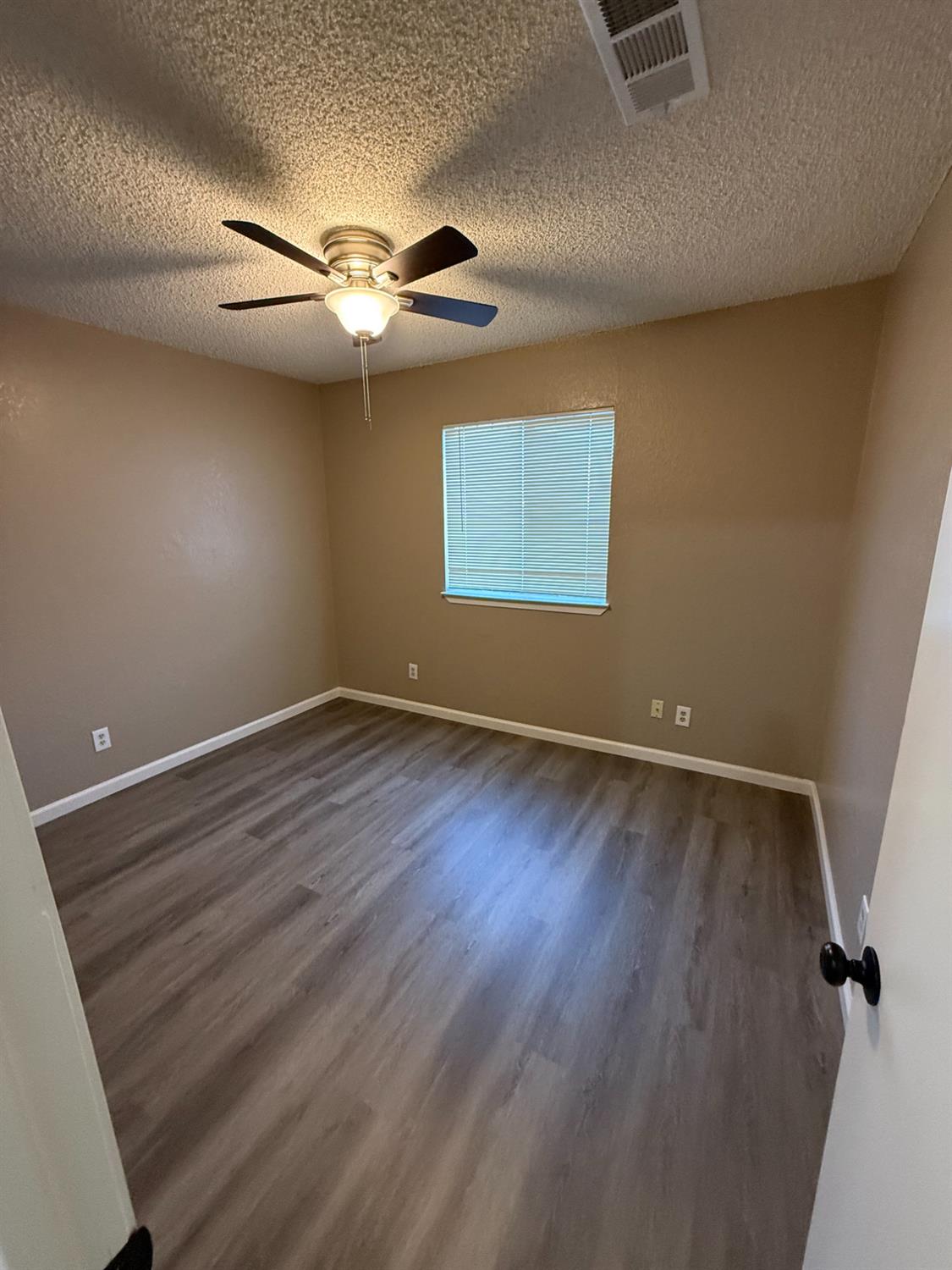 460 South Dearing Avenue Fresno, CA 93702 - Photo 4 of 23 wooden floor in an empty room with a window