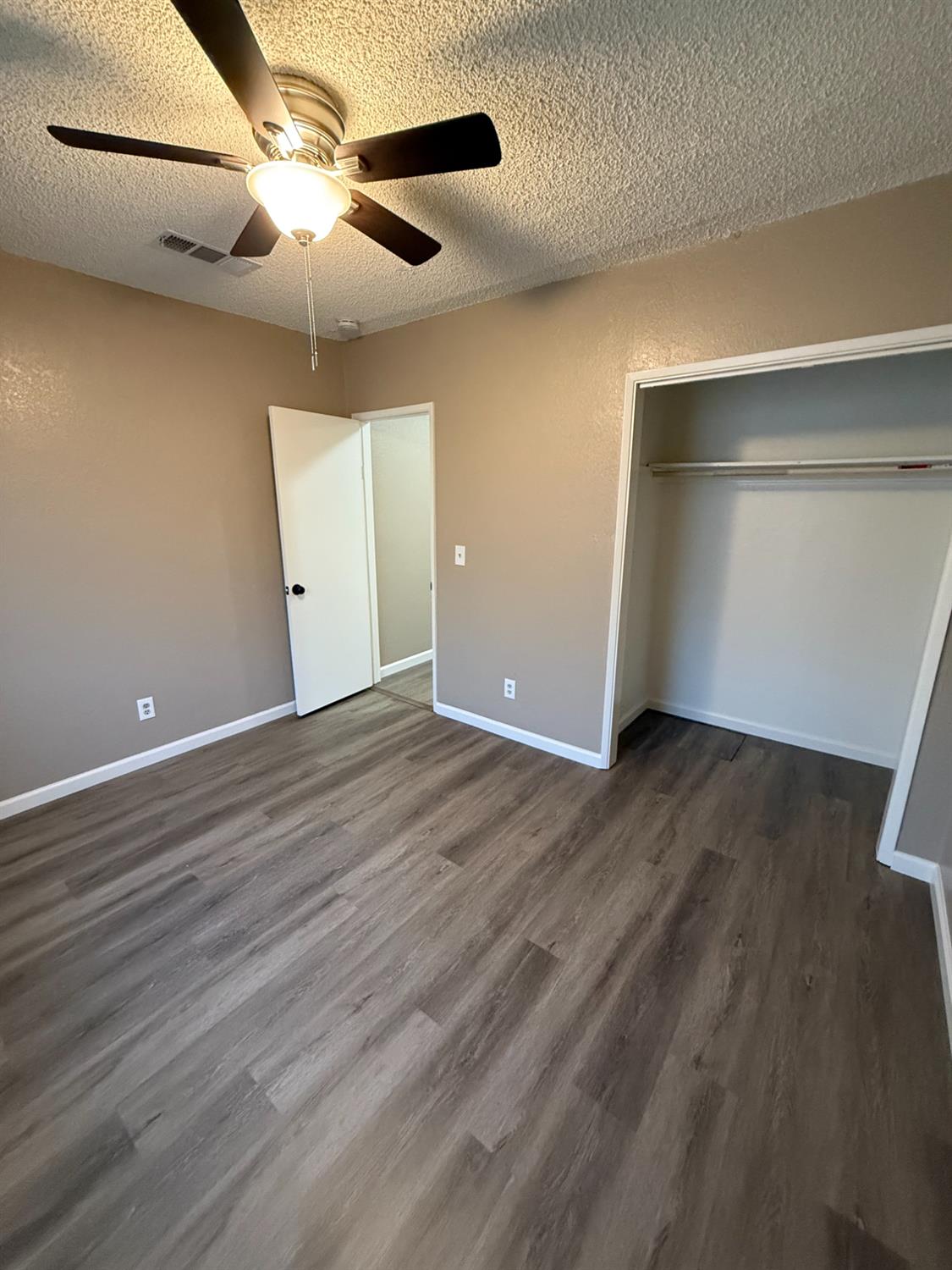 460 South Dearing Avenue Fresno, CA 93702 - Photo 5 of 23 a view of an empty room with wooden floor and a ceiling fan