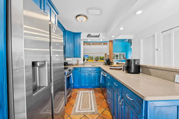 a kitchen with stainless steel appliances granite countertop a refrigerator a sink and a stove