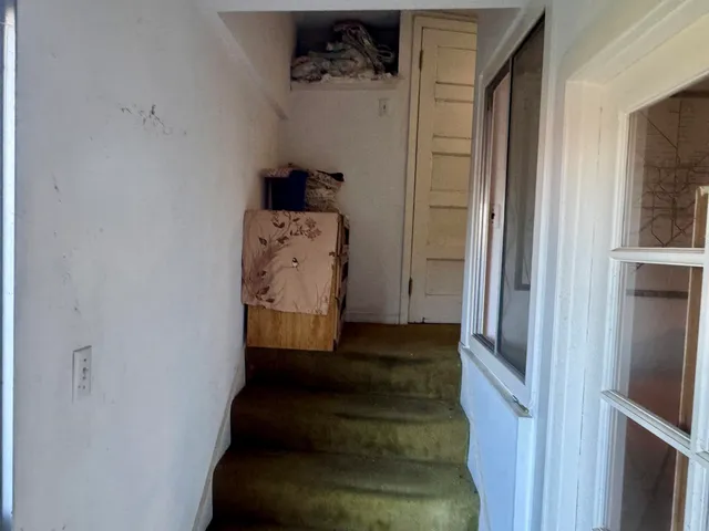 a bedroom with a bed and large windows