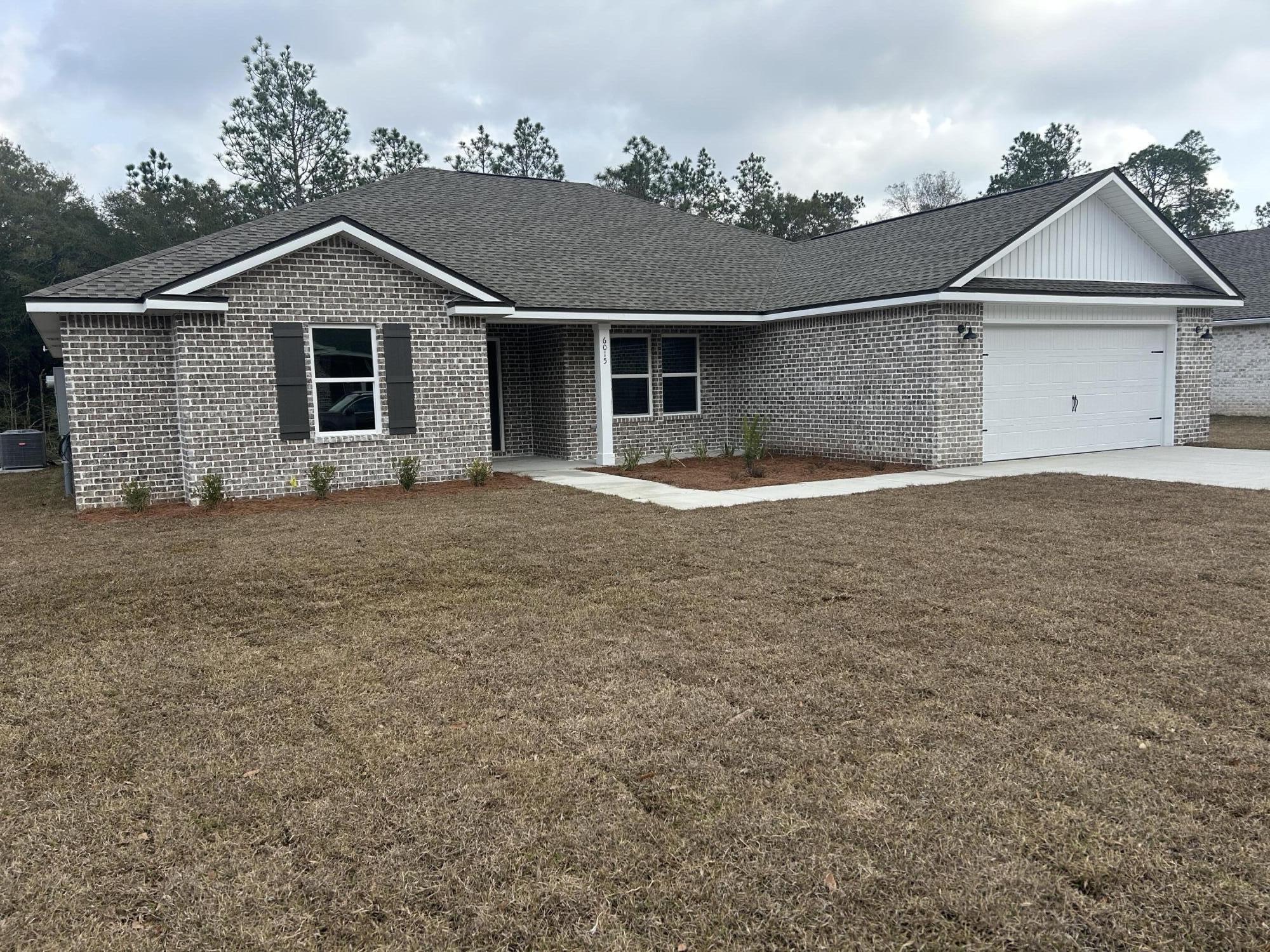 6015 Oak Hollow Way Crestview, FL 32539 - Photo 2 of 3 a front view of a house with a yard and garage