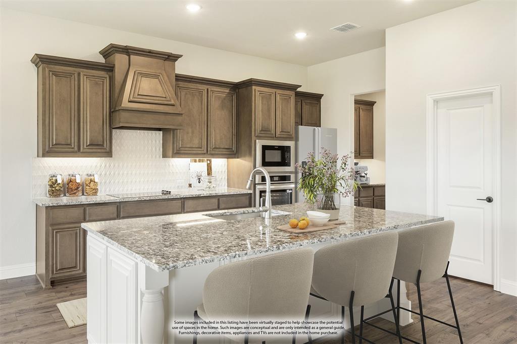 721 Seahawk Street Joshua, TX 76058 - Photo 13 of 40 a kitchen with kitchen island granite countertop a sink and cabinets