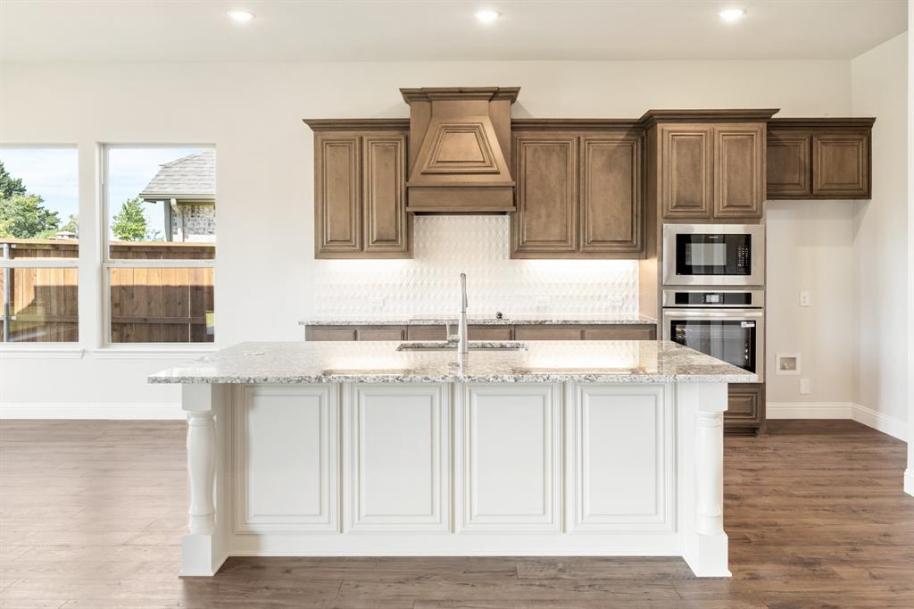 721 Seahawk Street Joshua, TX 76058 - Photo 14 of 40 a kitchen with stainless steel appliances granite countertop a stove a sink and a refrigerator