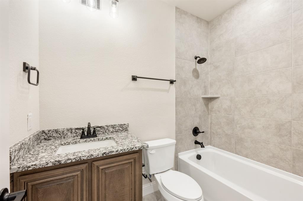 721 Seahawk Street Joshua, TX 76058 - Photo 25 of 40 a bathroom with a granite countertop sink toilet and shower