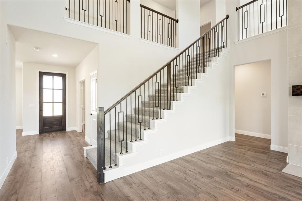 721 Seahawk Street Joshua, TX 76058 - Photo 27 of 40 a view of staircase with wooden floor and a chandelier