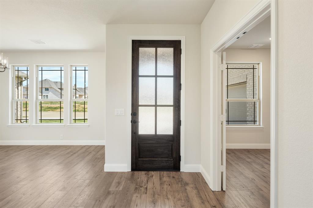 721 Seahawk Street Joshua, TX 76058 - Photo 4 of 40 an empty room with wooden floor and windows