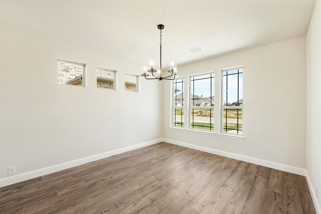 721 Seahawk Street Joshua, TX 76058 - Photo 7 of 40 an empty room with wooden floor fan and windows