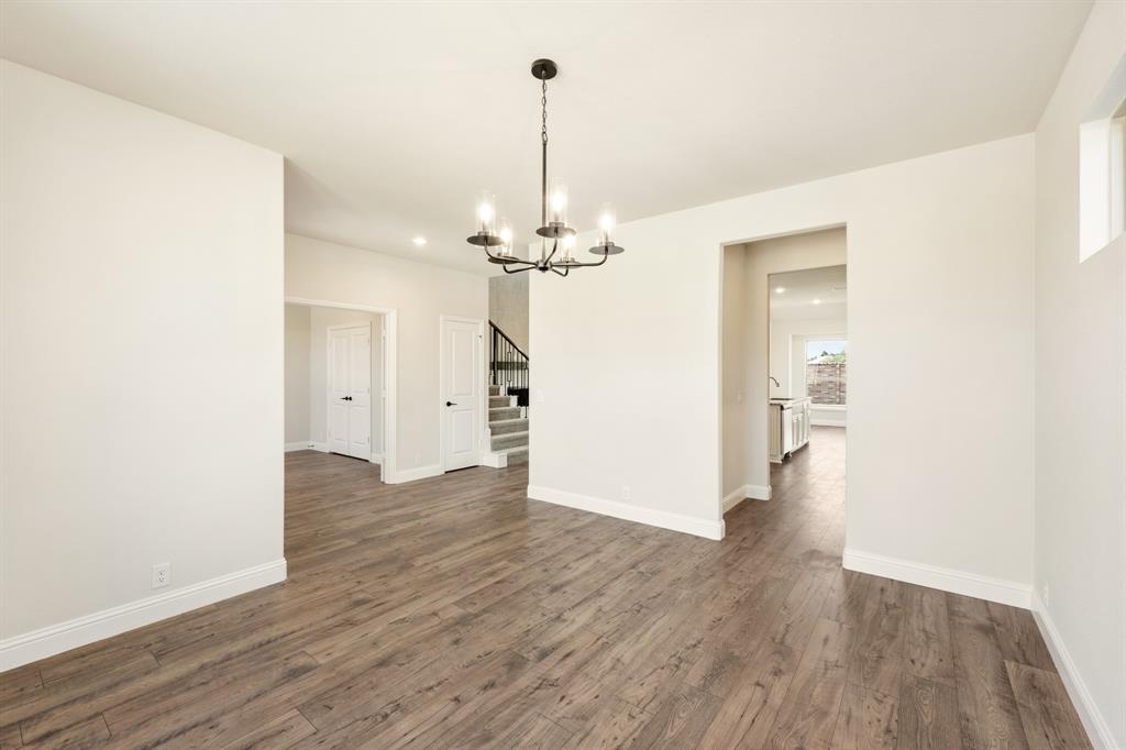721 Seahawk Street Joshua, TX 76058 - Photo 9 of 40 a view of a room with wooden floor and a ceiling fan