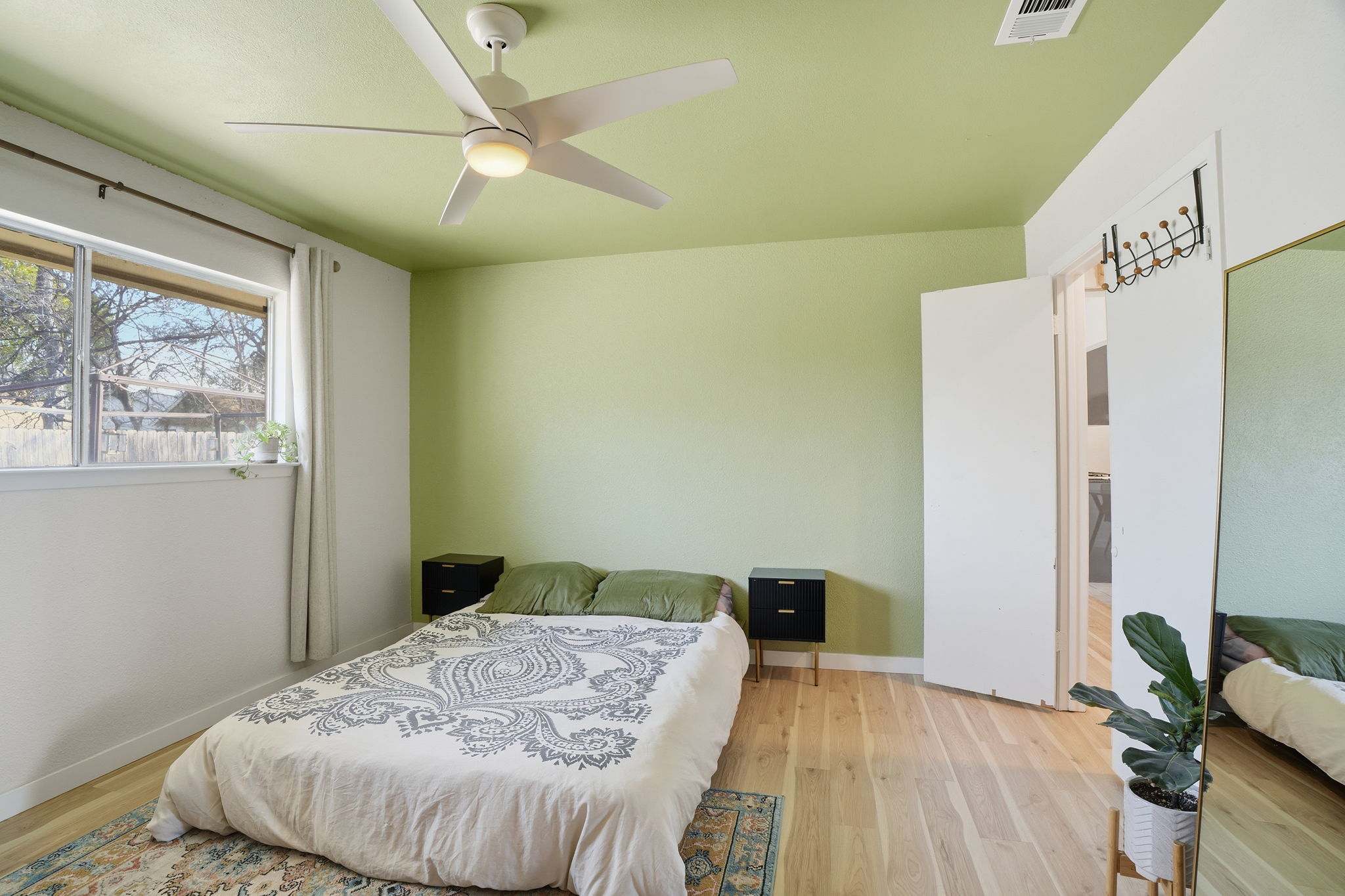 10305 Golden Quail Drive Austin, TX 78758 - Photo 16 of 39 a bedroom with a bed and a dresser with wooden floor