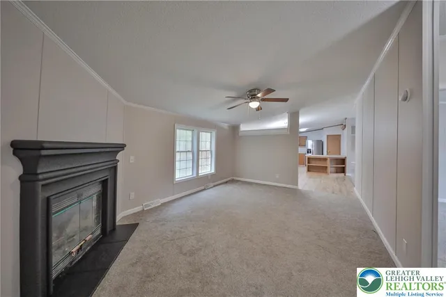 a view of empty room with fan and fireplace